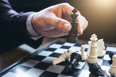 Cropped hand of businessman playing chess