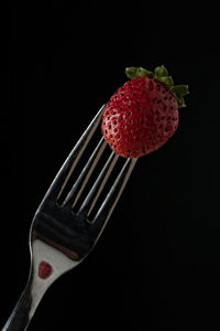 Close-up of strawberry over black background