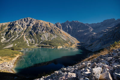Scenic view of snowcapped mountains against clear blue sky