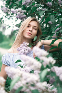 Young woman with flower petals on plant