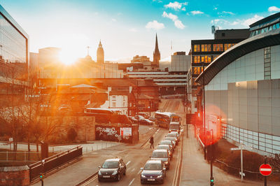 Cars on street amidst buildings in city against sky