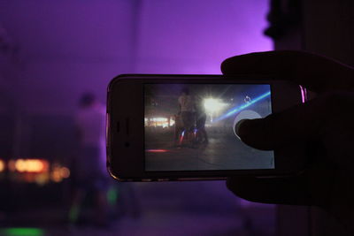 Man photographing through smart phone at night