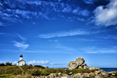 Rock formation by sea against blue sky