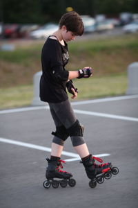 Full length of boy skateboarding on road