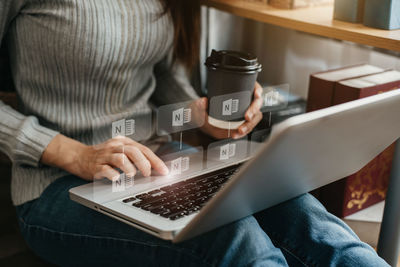 Midsection of man using laptop at home