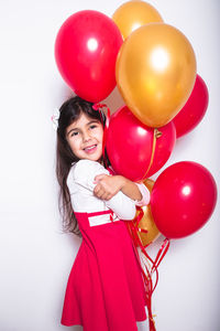 Portrait of a smiling girl holding balloons