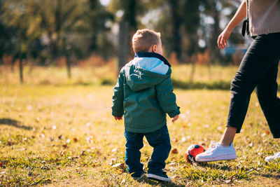 Little boy playing soccer with mother