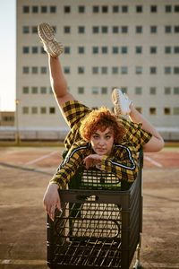 Alternative redhead with yellow shirt and a shopping cart