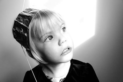 Close-up of girl looking away against wall