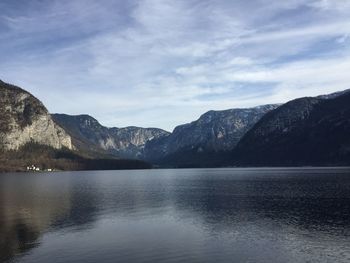 Scenic view of lake by mountains against sky