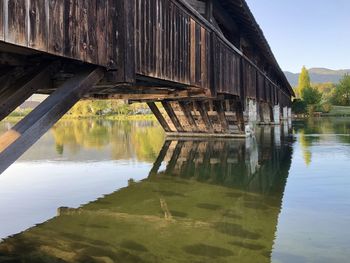 Bridge over lake by building against sky