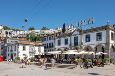 People on street against buildings in city