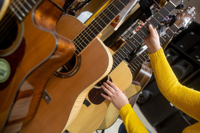 Cropped hand of woman holding guitars