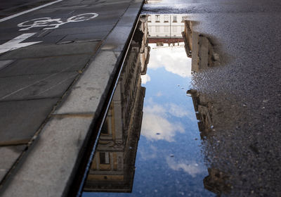 Reflection of building in puddle on road