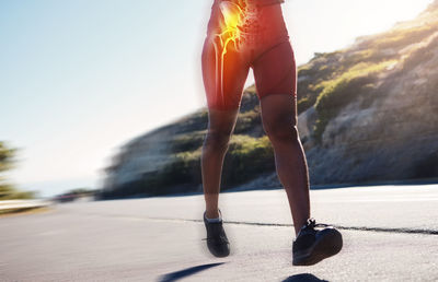 Low section of woman walking on road