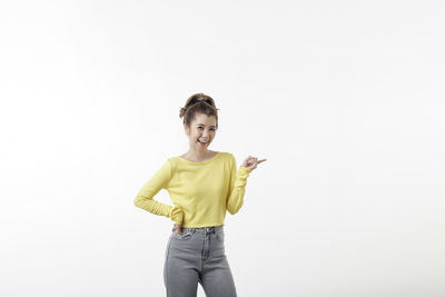 Portrait of smiling young woman against white background