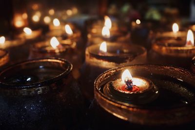 Close-up of lit tea light candles in temple