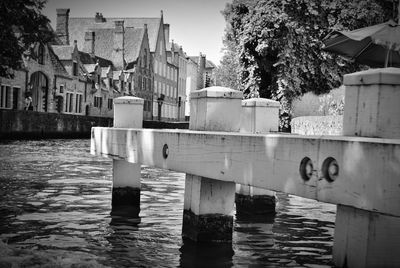 Buildings by river in city against sky