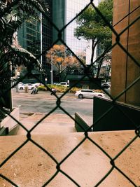 View of building seen through chainlink fence