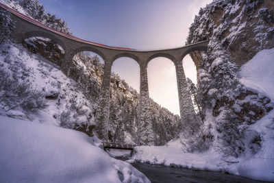 Snow covered arch bridge against sky during winter