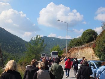 Rear view of people on mountain road against sky
