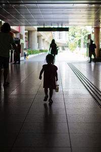 Rear view of people walking on floor