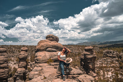 Rear view of man on rock against sky