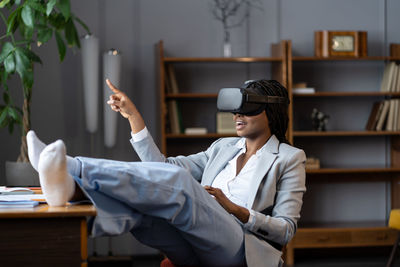 Excited african american business woman testing vr glasses, using virtual reality for remote work