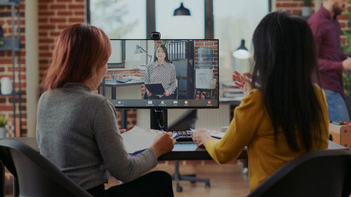 Businesswomen talking on video call at office