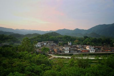 Houses in village against sky during sunset