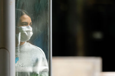 Portrait of man looking through window