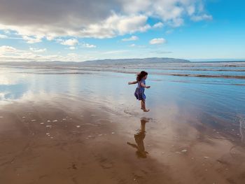 Full length of boy on beach against sky