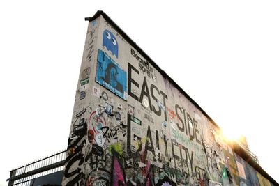 Low angle view of graffiti on building against sky