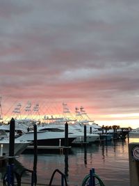 Pier at harbor against sky during sunset