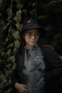 Portrait of boy standing against plants