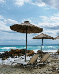 A picturesque sandy beach with beach umbrellas and deck chairs with background of the sea.