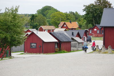 Rear view of people cycling on road in town