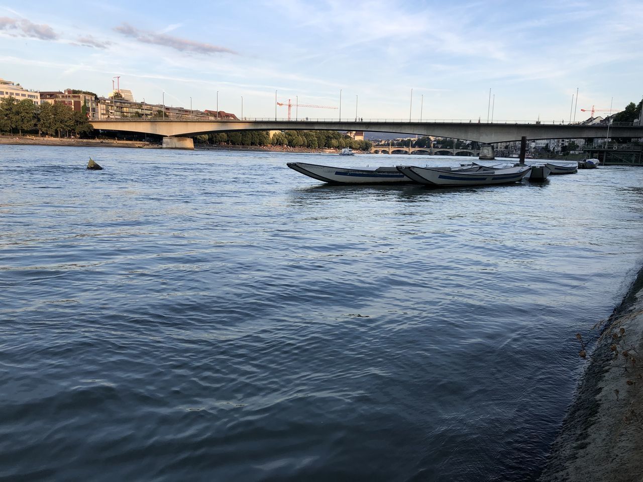 BOAT MOORED IN RIVER AGAINST SKY