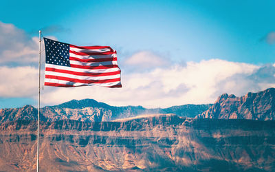 Red flag against mountain range against sky