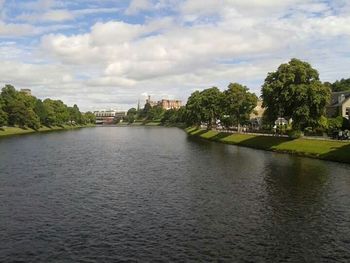 Scenic view of river against cloudy sky