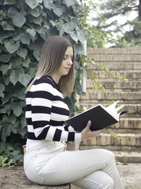 Portrait of young woman sitting on field