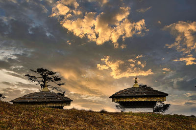 Built structure on field against sky during sunset