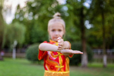 Portrait of cute girl blowing bubbles at park