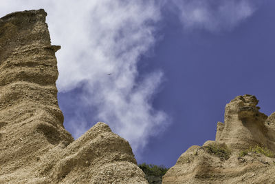 Low angle view of rock formations against sky