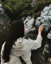 Rear view of woman standing on rock