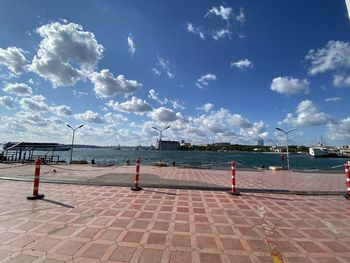 Footpath by sea against blue sky