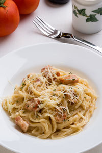 High angle view of spaghetti with carbonara in plate on table