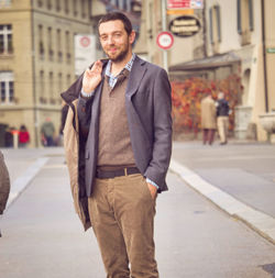 Portrait of young man standing on street in city