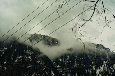 Low angle view of electricity pylon against sky