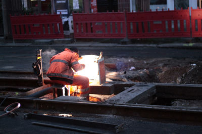 Rear view of worker welding at construction site
